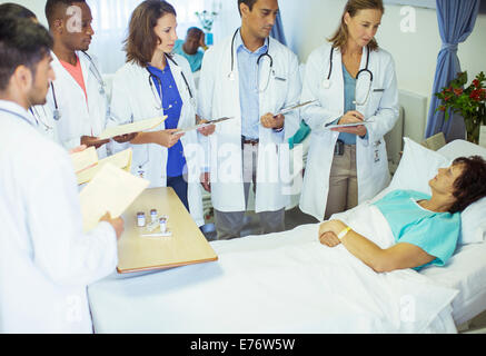 Doctor and residents examining patient in hospital Stock Photo