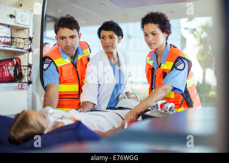 Doctor and paramedics examining patient in ambulance Stock Photo