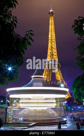 PARIS, FRANCE - AUGUST 8TH 2014: A vintage Carousel with the Eiffel Tower in the background in Paris on the 8th August 2014. Stock Photo