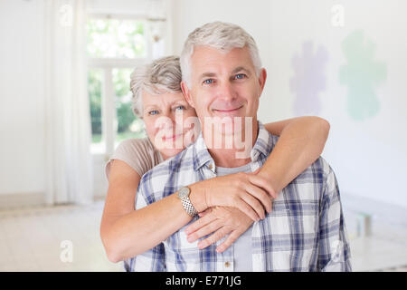 Older couple hugging in living space Stock Photo