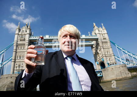 London, UK. Monday 8th September 2014. London Mayor Boris Johnson holding a bottle of water drawn from the source of the Thames with Tower Bridge as the backdrop. The bottle has been carried in Olympic torch fashion by hundreds of people conveying the bottle from the source to the mouth of the Thames. A highlight of Totally Thames, the new month-long promotion of river and riverside events delivered by Thames Festival Trust. Credit:  Michael Kemp/Alamy Live News Stock Photo