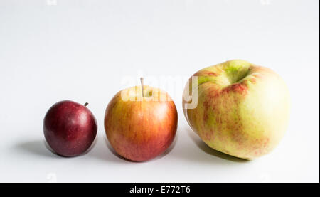 Three apples on white. Three apples in different sizes on white background. Stock Photo