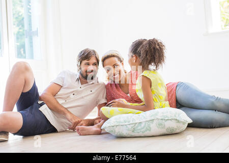 Family sitting on the ground in living space Stock Photo