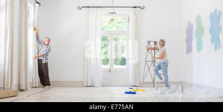 Older couple hanging curtains together Stock Photo