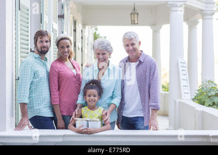 Family smiling on porch together Stock Photo