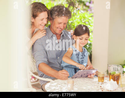 Grandparents playing on digital tablet with granddaughter Stock Photo