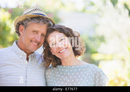 Older couple hugging outdoors Stock Photo