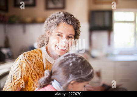 Mother and daughter playing with flour in the kitchen Stock Photo