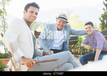 Three generations of men relaxing outdoors Stock Photo