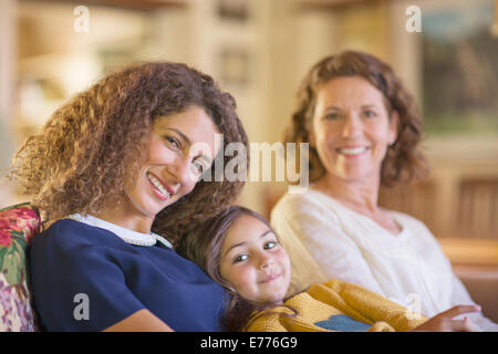 Three generations of women relaxing on couch together Stock Photo