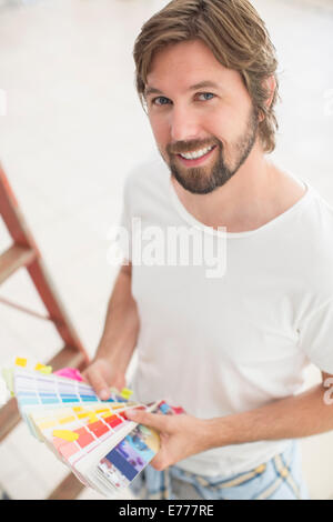 Man looking through color swatches Stock Photo