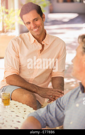 Father and son sat at table enjoying the outdoors Stock Photo