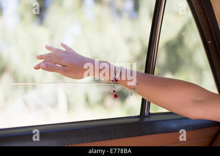 Woman feeling wind on her hand through car window Stock Photo