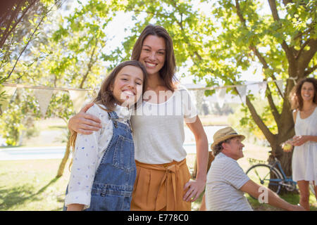 Mother and daughter hugging at family picnic Stock Photo