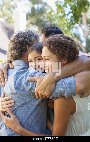 Family hugging outdoors Stock Photo