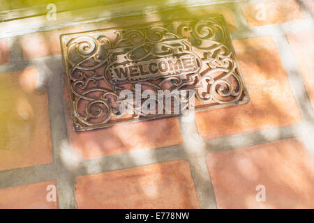 Sun shining through tree branches on welcome mat Stock Photo