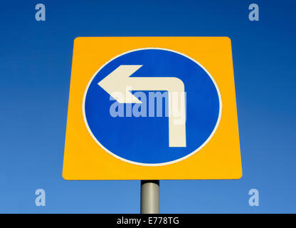 Turn left road sign set against a blue sky Stock Photo