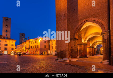 Arched passage and medieval towers on cobbled town square early in the morning in Alba, Italy. Stock Photo