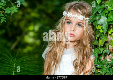 Close up portrait of cute blond girl in the woods. Stock Photo