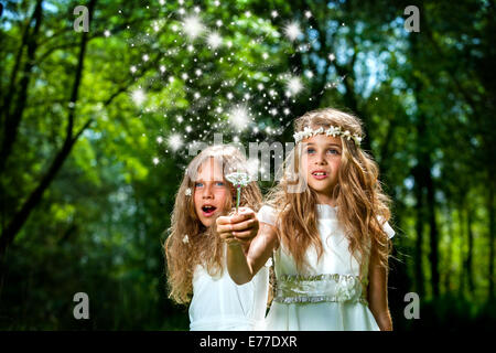 Fantasy portrait of cute girls with magic wand in forest. Stock Photo