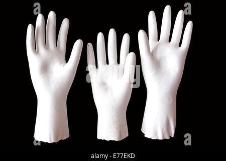 three white molded raised hands on black background Stock Photo