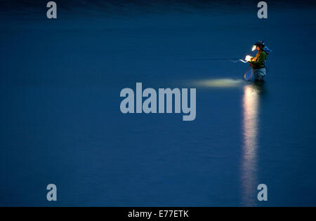 Fly fisherman in river at night on the North Platte in Wyoming, USA. Stock Photo