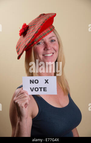 Scottish Independence Referendum no vote from this smiling female voter wearing traditional Tam o Shanter hat Stock Photo