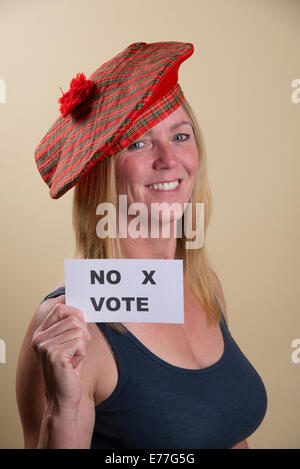 Scottish Independence Referendum no vote from this smiling female voter wearing traditional Tam o Shanter hat Stock Photo