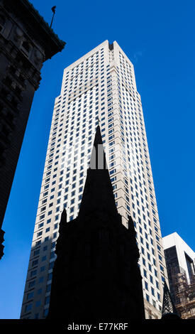 The silhouetted spire of St Patrick's Cathedral, Midtown Manhattan, New York contrasts with a modern skyscraper background Stock Photo