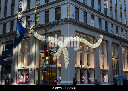 New York Bulgari illuminated serpent, seasonal Christmas decorations on the exterior of their upscale boutique store on 5th Avenue, downtown New York Stock Photo