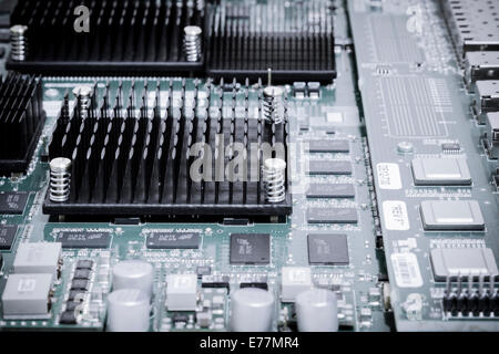 Circuit board of a powerful server computer with chips, capacitors, and heat sinks visible Stock Photo