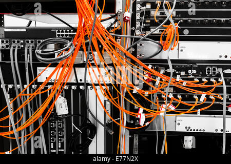 Fiber cables plugged into a high end router machine at a computer data center supporting cloud computing Stock Photo