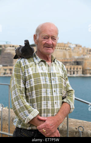 Man with a pigeon on his shoulder Stock Photo