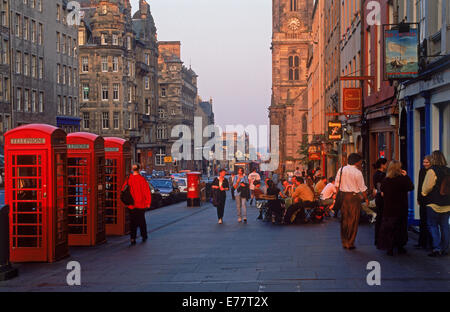 Telephone booths, pedestrians and pubs along The Royal Mile in Edinburgh in sunset light Stock Photo