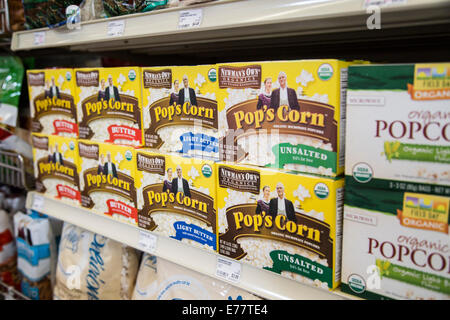A natural foods grocery store aisle with a shelf of natural microwave popcorn boxes. Stock Photo