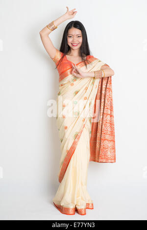 Full length Asian Indian female in dancing pose on plain background. Stock Photo