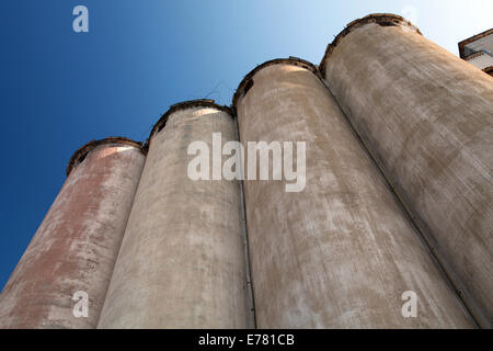 Row of grain silos under deep blue sky Stock Photo
