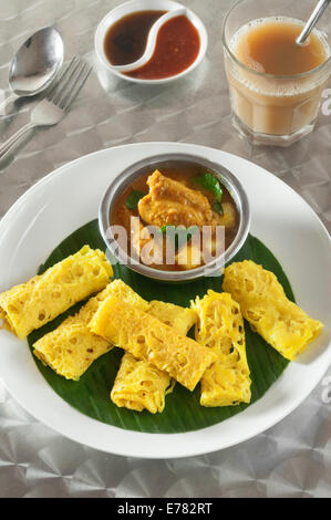 Roti jala with kari ayam. Lacy pancakes with chicken curry. Malaysia Food Stock Photo