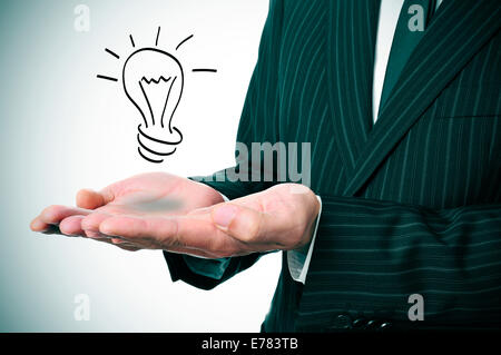 a man wearing a suit with a lightbulb drawn in his hand Stock Photo