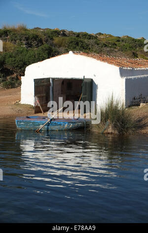 Boat house and old blue rowing boat, Sanitja, near Fornells, Menorca, Spain Stock Photo
