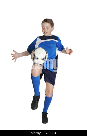 Boy in sports wear plays football isolated on white background Stock Photo