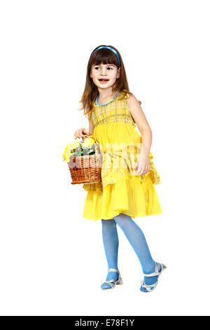 Little girl in yellow dress with blue carries basket with flowers. Full height portrait isolated on white background Stock Photo