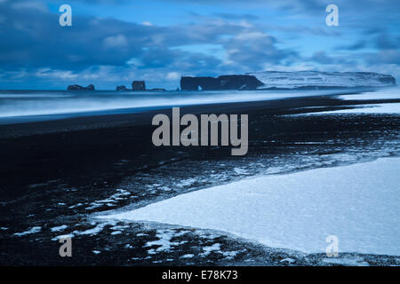 the view along Reynisfjara black sand beach near the village Vík í Mýrdal towards  Dyrhólaey in winter, southern Iceland Stock Photo