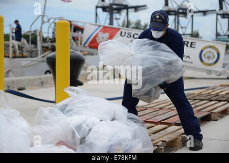 A crew member aboard the Coast Guard Cutter Legare offloads seized cocaine at Coast Guard Base Miami Beach, Florida, Sep. 4, 2014. The crew offloaded approximately 2,800 kilograms of cocaine worth an estimated wholesale value of more than $93 million. Stock Photo
