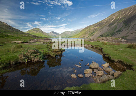 Wastwater, in Lake District of Cumbria, England,surrounded by mountain peaks with blue sky reflected in calm water of lake Stock Photo