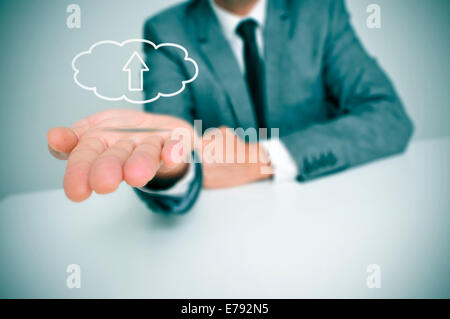 a man with a drawing of a cloud with an arrow inside, depicting the concept of upload to the cloud storage Stock Photo
