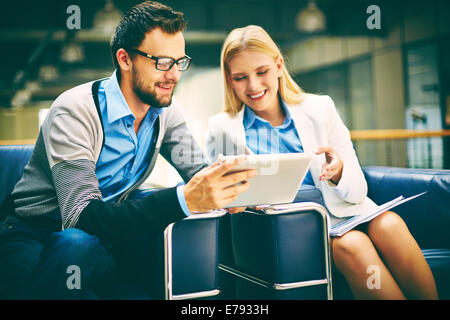 Two business people using touchpad during discussion at meeting Stock Photo