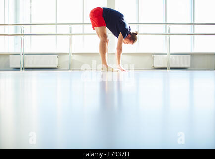 Side view of young sportsman doing physical exercises in gym Stock Photo
