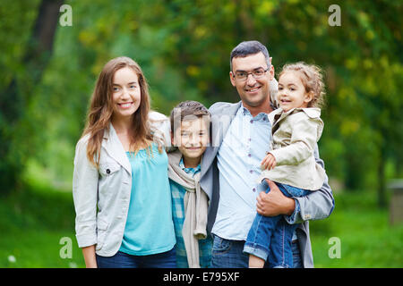 Happy family members looking at camera in natural environment Stock Photo