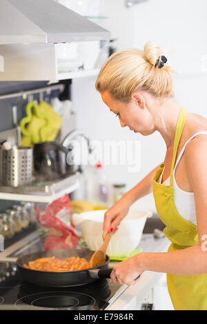 Young Mother Cooking at Home. Stock Photo